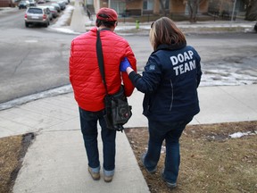 A DOAP team worker helps a man after he fell in Bridgeland in this 2015 file photo. Gavin Young/Postmedia Network