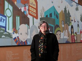Cheri Macaulay stands next to one of the many murals she helped initiate in her neighbourhood of Brentwood in Calgary, Alberta on December 15, 2011.