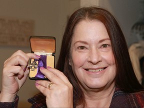 Tracey Scott shows a Memorial Cross medal which was among antique family photos returned in Calgary on Sunday, November 3, 2019. The photos and war medals were found in a donation to Goodwill and after some investigation by Goodwill staff, the items were returned to Scott and her family. Jim Wells/Postmedia