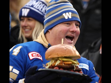 A Winnipeg fan gets a Walby Burger delivered to stands during the 107th Grey Cup CFL Championship football game in Calgary at McMahon Stadium Sunday, November 24, 2019. Jim Wells/Postmedia