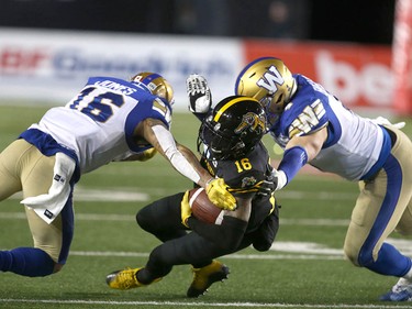 Hamilton Ti Cats Brandon Banks (C) is tackled by a pair of WInnipeg Blue Bombers in the first quarter during the 107th Grey Cup CFL Championship football game in Calgary at McMahon Stadium Sunday, November 24, 2019. Jim Wells/Postmedia