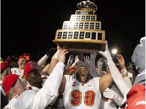 CP-Web.  University of Calgary Dinos' J-Min Pelley raises the trophy with teammates after winning the U Sports Vanier Cup university football championship against the University of Montreal Carabins, in Quebec City, Sunday, Nov. 23, 2019.
