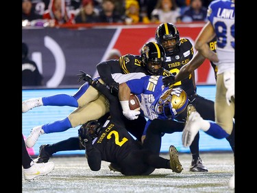 Winnipeg Blue Bombers, Andrew Harris  is taken down by the Hamilton Tiger-Cats at McMahon stadium during the 107th Grey Cup in Calgary on Sunday, November 24, 2019. Darren Makowichuk/Postmedia