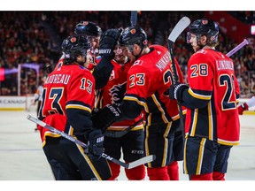 Nov 7, 2019; Calgary, Alberta, CAN; Calgary Flames left wing Johnny Gaudreau (13) celebrates with teammates after scoring a goal against the New Jersey Devils during the third period at Scotiabank Saddledome. Calgary Flames won 5-2. Mandatory Credit: Sergei Belski-USA TODAY Sports ORG XMIT: USATSI-405238