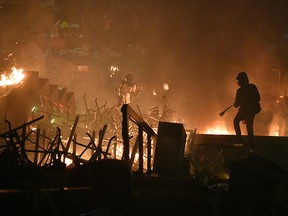 Anti-government protesters watch as a large fire is started by other protesters in a staircase at the main entrance that leads into the Hong Kong Polytechnic University  on Nov. 18, 2019.