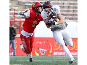 Marauders Slotback Tommy Nield is tackled by Dino's DB Nick Statz during the first half of action of the 2019 Mitchell Bowl Calgary Dino's take on the McMaster Marauders at home from McMahon Stadium on Saturday, November 16, 2019. Brendan Miller/Postmedia