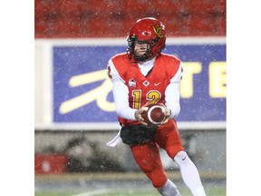 Calgary Dinos quarterback Adam Sinagra prepares a hand off in the backfield during U Sports Canadian college football action between the University of Calgary Dinos and the Manitoba Bisons in Calgary on Friday, October 12, 2018. Jim Wells/Postmedia
