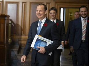 CP-Web.  Quebec Finance Minister Eric Girard walks with his staff to present an economic update Thursday, November 7, 2019 at his office in Quebec City.