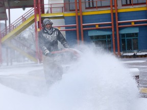 Khaled Esmail clears the entrance into Eau Claire Market as Calgary was hit by another blast of winter on Wednesday, Nov. 27, 2019.