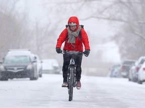 Nicole Estabrooks pedals down a snowy Calgary street on Nov. 5, 2019. Calgary has already seen several snowstorms since September.