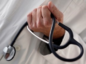 FILE PHOTO: A photo illustration shows a French general practitioner holding a stethoscope in a doctor's office in Bordeaux