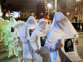 Activists dress in white and hold images of slain members of the LGBTQ community during a demonstration to commemorate Transgender Day of Remembrance in New York City, U.S., November 20, 2019.  REUTERS/Lucas Jackson ORG XMIT: LJJ006