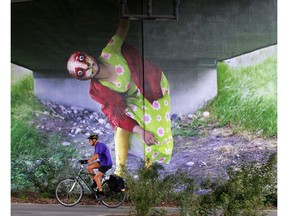 A new mural on the bridge support for the 4th avenue flyover into downtown Calgary adds a dynamic presence behind pathway users on Monday August 26, 2019. Calgary artist Katie Green created the large than life art.  Gavin Young/Postmedia