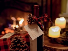 romantic bottle of wine and gift on table by fireplace on Christmas. Getty Images/iStockphoto
