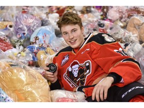 Calgary Hitmen sniper Carson Focht shows off some of the Teddy bears collected after scoring during the Teddy Bear Toss game against the Red Deer Rebels at the Saddledome on Sunday. Photo by Azin Ghaffari/Postmedia.