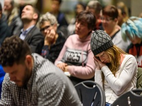 Missy Rector, who has been homeless for the past eight months, prays during the city-wide candlelight memorial service held in the Atrium of the Calgary Municipal Building in memory of those who have passed away while experiencing homelessness on the longest night of the year on Saturday, December 21, 2019. Rector found her best friend three hours after she had committed suicide and stopped caring about things to the extent that she became homeless. Azin Ghaffari/Postmedia