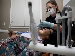 Dental hygienist Candice Boyce cleans Skylette Peecheemow's teeth at Baseline Village Dental, in Sherwood Park Friday Aug. 23, 2019. The clinic was providing complimentary dental cleanings for teen parents and their families in partnership with the Terra Centre. Photo by David Bloom