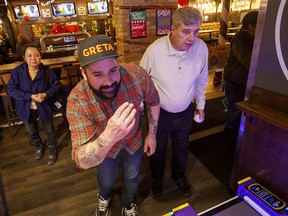 GRETA Bar's Chris Jamiesin, left, and guest Marty Hilton play the Ice Ball game as GRETA Bar and The Mustard Seed offer a dinner and unlimited free games at Greta Arcade, Bar and Street food in Calgary, Ab., on Monday December 23, 2019. Mike Drew/Postmedia