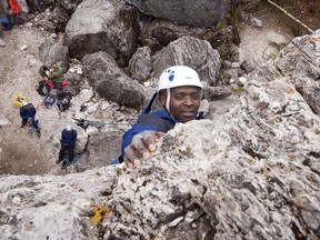 British Army Royal Logistic Coup Lance Corporal Boniface Mnjoroge, from Guterschoh, Germany, reaches for the top as he climbs up Rundle Rock in Banff during a climbing class with the Yamnuska Climbing school in this undated file photo.