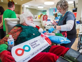 Santa Claus (Kelly Toombs) gives blood at Canadian Blood Services in Eau Claire, with assistance from Rayna Glazenburg on Tuesday, Dec. 17, 2019.