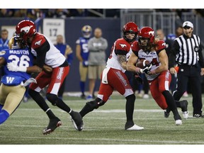 CP-Web.  Calgary Stampeders quarterback Bo Levi Mitchell (19) hands off to Ante Milanovic-Litre (34) against the Winnipeg Blue Bombers during the first half of CFL action in Winnipeg Friday, October 25, 2019.