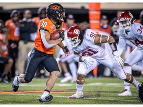 Nov 30, 2019; Stillwater, OK, USA; Oklahoma State Cowboys running back Chuba Hubbard (30) runs the ball against Oklahoma Sooners defensive lineman Dillon Faamatau (91) during the second half at Boone Pickens Stadium. Mandatory Credit: Rob Ferguson-USA TODAY Sports ORG XMIT: USATSI-404607