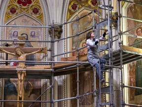 Jennifer Fotheringham, an art conservator, works on the restoration of the murals over the altar at Saint Mary's Cathedral Basilica in Halifax on Monday, Dec. 2, 2019. The century-old frescos were painted over in the 1950s and Fotheringham is able to remove the old paint to reveal the images and repair any damage.