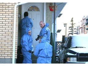 Calgary Police Crime Scene Unit and a member of the Medical Examiner's office enter a duplex in the 400 block of 28 Ave. N.E. in Calgary on Sunday. Photo by Jim Wells/Postmedia.