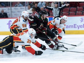 Nov 16, 2019; Glendale, AZ, USA; Arizona Coyotes center Clayton Keller (9) skates against Calgary Flames defenseman Michael Stone (26) and Calgary Flames defenseman Oliver Kylington (58) and Calgary Flames center Sam Bennett (93) during the second period at Gila River Arena. Mandatory Credit: Joe Camporeale-USA TODAY Sports ORG XMIT: USATSI-405294