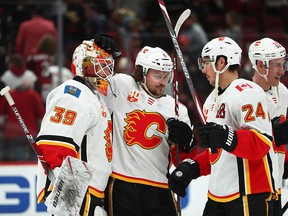 Dec 10, 2019; Glendale, AZ, USA; Calgary Flames goalie Cam Talbot (39) celebrates with defenseman Rasmus Andersson (4) and Travis Hamonic (24) after defeating the Arizona Coyotes in the third period at Gila River Arena. Mandatory Credit: Mark J. Rebilas-USA TODAY Sports ORG XMIT: USATSI-405473