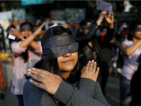 Protestors wearing blindfolds take part in a protest in solidarity with rape victims and to oppose violence against women in India, in New Delhi, India December 7, 2019. REUTERS/Adnan Abidi ORG XMIT: DEL206