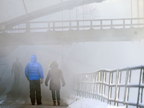 Pedestrians cross the Centre Street Bridge underpass covered in a fog rising from Bow River in a -30 weather on Wednesday, January 15, 2020. Azin Ghaffari/Postmedia