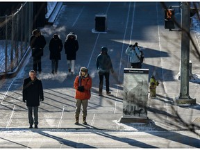 Pedestrians wait to cross 6 Avenue S.E in Downtown Calgary all bundled up on a -30 weather on Wednesday, January 15, 2020.