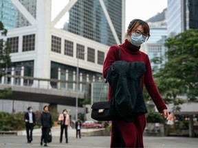 Pedestrians wear face masks as they walk through a park in Central district on January 23, 2020 in Hong Kong, China.