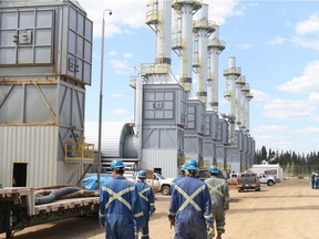 Employees at the Cenovus Christina Lake oilsands facility, located south of Fort McMurray, walk past gravity separators as they begin their shift in this May 2012 file photo.