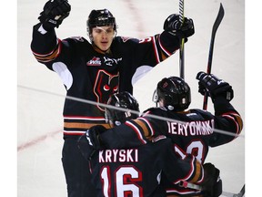 Calgary Hitmen Egor Zamula raises his hands as he celebrates with Jake Kryski and Vladislav Yeryomenko after Kryski scored on the Saskatoon Blades during WHL in Calgary on Sunday October 28, 2018. Gavin Young/Postmedia