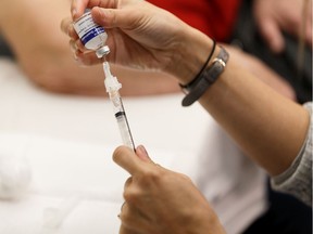 A nurse gives a patient a flu shot at East Edmonton Health Centre in Edmonton on Monday, Oct. 28, 2019.