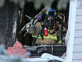 A Calgary Fire Department fire inspector clears debris from a townhouse in the 3800 block of Fonda Way S.E. on Thursday morning January 2, 2019. A fire in the structure late Wednesday night caused the evacuation of 16 resident but there were no injuries.  Gavin Young/Postmedia