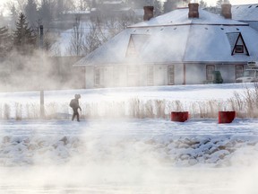 A pedestrian walks beside the steamy Bow River on another frigid day in Calgary, Tuesday, January 14, 2020.