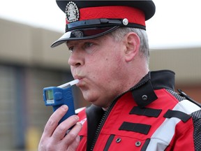 Const. Andrew Fairman, with the Calgary Police Service alcohol and drug recognition unit, demonstrates a roadside breath-screening device.