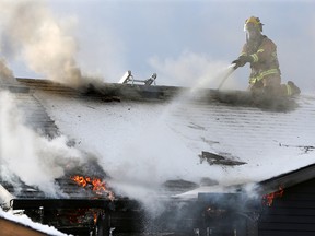 Calgary firefighters attack a fire from the roof of a home on Templeby Drive N.E. on Sunday January 19, 2020.