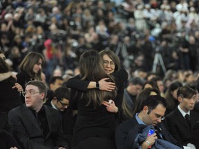 TOPSHOT - Mourners console each other as they gather at a memorial service for the victims of Ukrainian Airlines flight PS752 crash in Iran at the Saville Community Sports Centre in Edmonton, Canada on January 12, 2020. (Photo by Walter Tychnowicz / AFP)