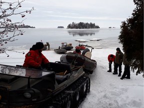 This image released by Surete du Quebec shows rescue personnel at Lake Saint-Jean, Quebec, on January 25, 2020, preparing for recovery operations for four French snowmobilers. - Canadian searchers on January 24 found the body of one of five French snowmobilers whose machines fell through the ice of a frozen lake, police said. A spokesman acknowledged that the chances of finding the group alive had dimmed, but police were "keeping up hope" of recovering their bodies. The search for the snowmobilers includes divers, sonar operators and police backed by helicopters in the area about 225 kilometers (140 miles) north of Quebec City.