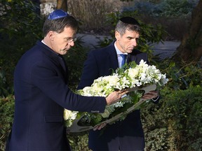 Prime Minister Mark Rutte (L) and State Secretary Paul Blokhuis (Health, Welfare and Sport) lay a wreath at the Auschwitz Never Again monument during during the National Holocaust Remembrance Day in Amsterdam, on 26 January 2020. (Photo by - / ANP / AFP) / Netherlands OUT (Photo by -/ANP/AFP via Getty Images)