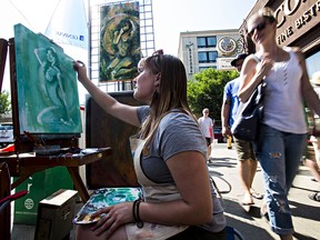 Andrea Schmidt works on a painting during the Art Walk on Whyte Avenue in Edmonton on July 12, 2014.