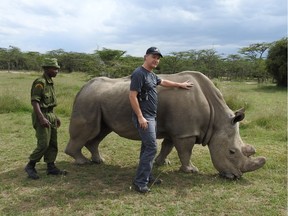 Axel Moehrenschlager, director of conservation efforts at the Calgary Zoo, with a rhinoceros in Africa.