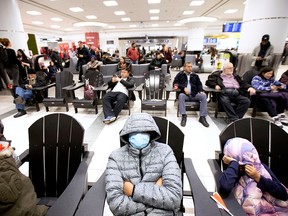 Lyndon Gorospe waits for a family friend while wearing a mask at Pearson airport arrivals, shortly after Toronto Public Health received notification of Canada's first presumptive confirmed case of novel coronavirus, in Toronto, Jan. 26, 2020.