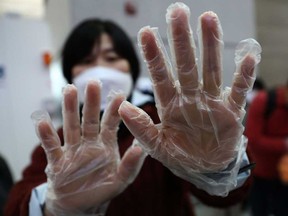 A South Korean woman wear plastic glove at the Incheon International Airport on Monday in Incheon, South Korea. South Korea confirmed its fourth case of the deadly coronavirus which emerged last month in the city of Wuhan in China. Ontario has confirmed two presumptive cases of the virus.