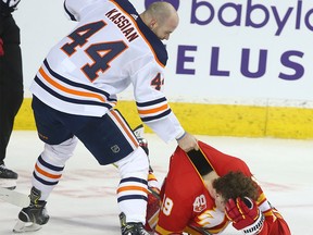 Oilers Zack Kassian lays into Flames Matthew Tkachuk in retaliation for a hit behind the net at the Saddledome on Saturday, Jan. 11, 2020.