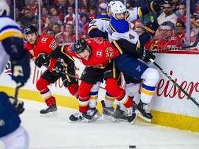 Jan 28, 2020; Calgary, Alberta, CAN; Calgary Flames right wing Buddy Robinson (53) and St. Louis Blues defenseman Carl Gunnarsson (4) battle for the puck during the first period at Scotiabank Saddledome. Mandatory Credit: Sergei Belski-USA TODAY Sports ORG XMIT: USATSI-405768